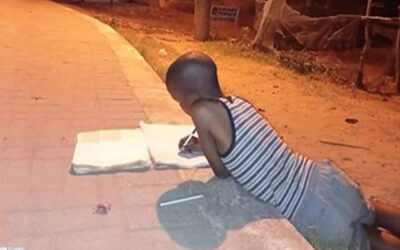 Child learning under a street lamp